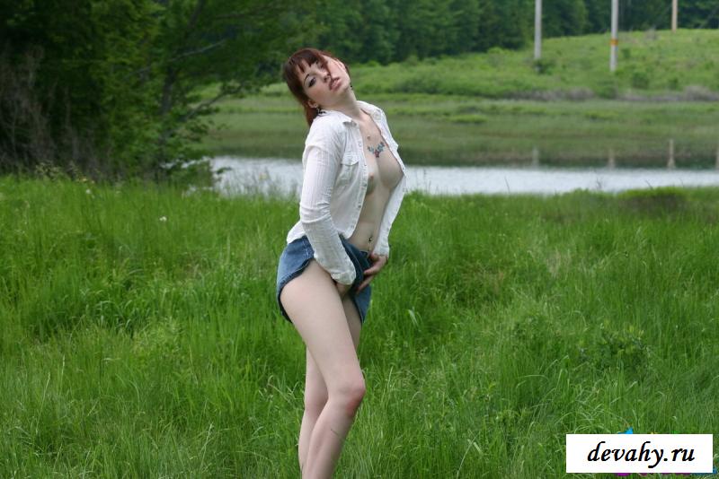 На фото голой молоденькой девушки на траве показала грудь